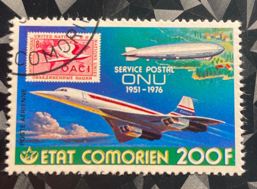 Timbre de poste aérienne commémorant le 25e anniversaire de l'Administration postale des Nations Unies avec représentation du Concorde et d'un dirigeable