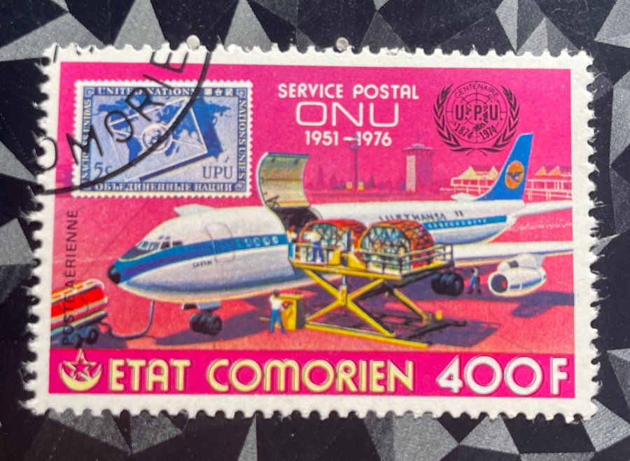 Timbre de poste aérienne commémorant le 25e anniversaire de l'Administration postale des Nations Unies avec chargement de fret sur un avion Lufthansa
